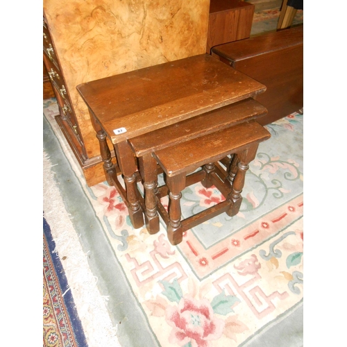 82 - A nest of three oak occasional tables on baluster turned legs and straight stretchers, the largest -... 