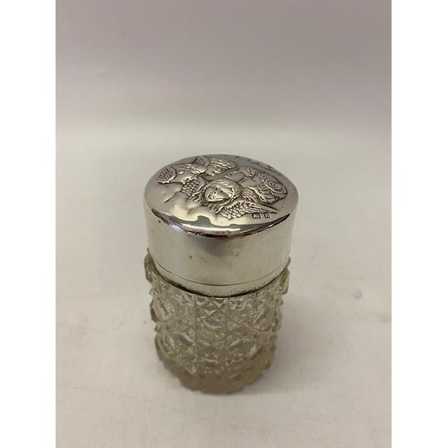 139 - A cylindrical hobnail cut glass scent bottle, the silver lid with repousse decoration of angel heads... 