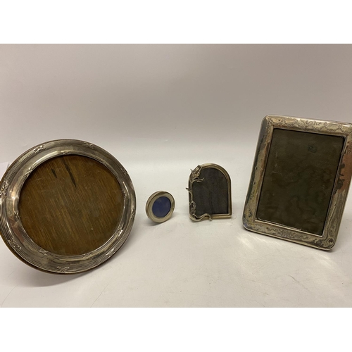 159 - A circular silver photograph frame with reeded and ribbon tie decoration - 7 1/4in. dia., a rectangu... 