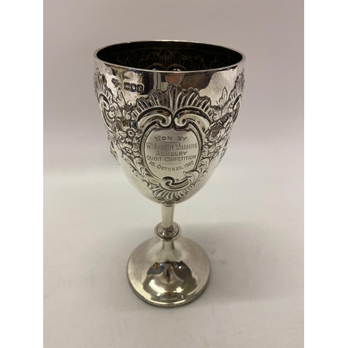 168 - A large presentation silver goblet with repousse flower and leaf scroll decoration, on turned column... 