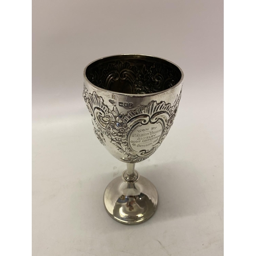 168 - A large presentation silver goblet with repousse flower and leaf scroll decoration, on turned column... 