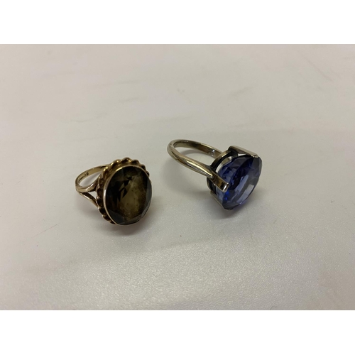 199 - A lady's ring set blue stone, on a 9ct. white gold shank and a lady's ring set smokey quartz coloure... 