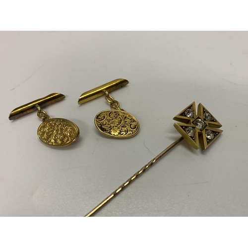 208 - A pair of 15ct. gold cufflinks and a gold coloured metal stick pin, the top in the form of a cross i... 