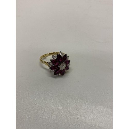 217 - A lady's ring of flower form set with diamonds and rubies, on an 18ct. gold shank