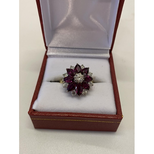 217 - A lady's ring of flower form set with diamonds and rubies, on an 18ct. gold shank