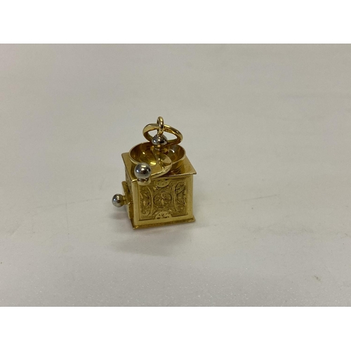 223 - An 18ct. gold charm in the form of a coffee grinder