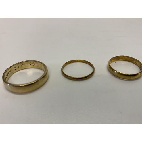 226 - A 9ct. gold wedding band and two gold coloured metal wedding bands