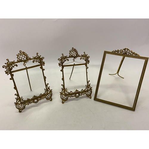 233 - A pair of brass photograph frames with scroll decoration, easel backs and one other with ribbon tie ... 