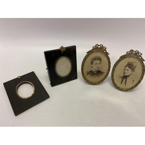 234 - Two 19th Century ebonised miniature frames and two oval brass coloured metal frames with ribbon tie ... 