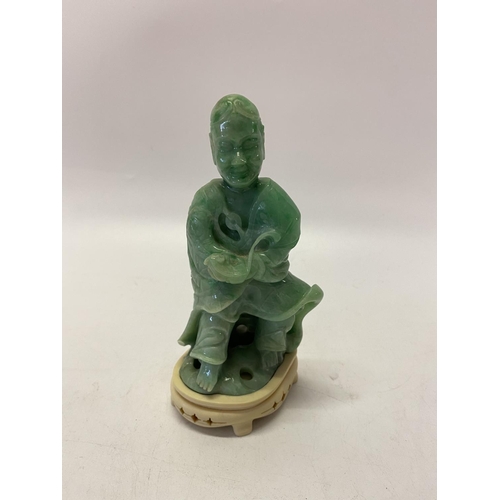 237 - A Chinese carved jade figure of a deity in robes, on a pierced ivory base - 5 1/2in. high