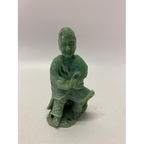 237 - A Chinese carved jade figure of a deity in robes, on a pierced ivory base - 5 1/2in. high