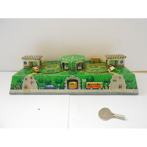 373 - A German WV tin plate clockwork bus station toy - 9 1/2in. wide and a Japanese TPS friction tin plat... 