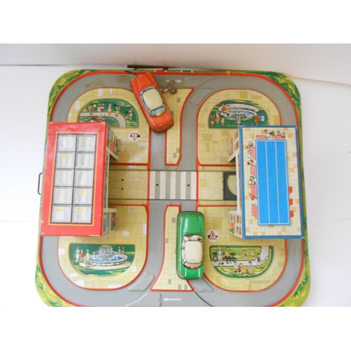 375 - A Western Germany 1960 tin plate clockwork road circuit and two cars - 13in. x 12in. (possibly Techn... 