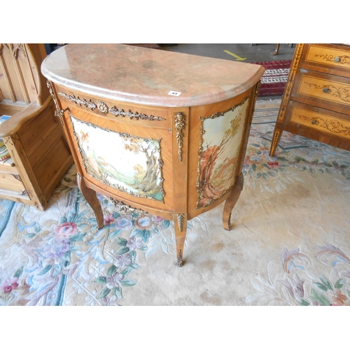 64 - A reproduction Italian style commode with variegated marble top, door and sides with painted decorat... 