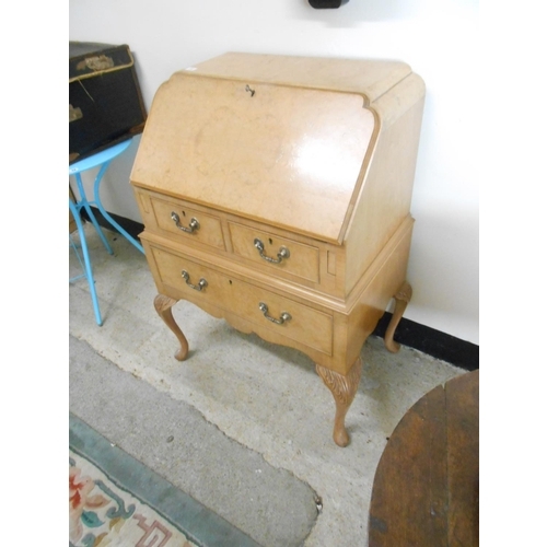 34 - A bleached walnut bureau with hinged fall front enclosing fitted interior above two narrow and one w... 