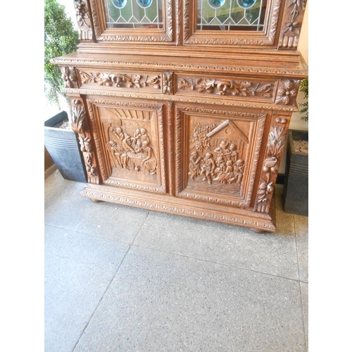 61 - A Victorian oak cabinet, the upper part with leaf scroll carved frieze above two leaded glass doors ... 