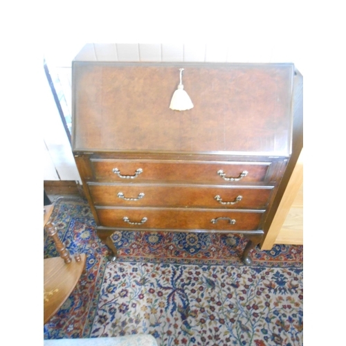 72 - A walnut bureau with hinged fall front above three wide drawers, on cabriole legs - 30in. wide and a... 