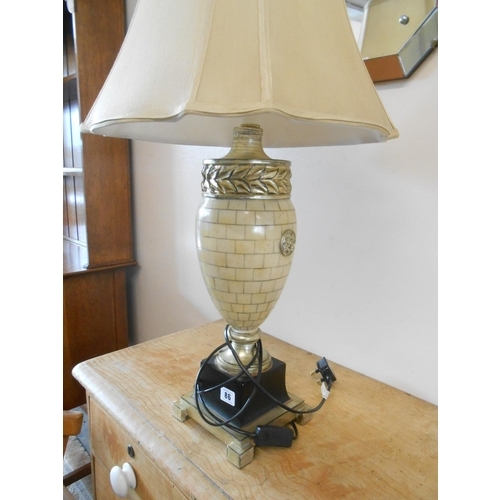 86 - A pair of modern ivory style urn shaped tablelamp bases on black and gilt metal bases, complete with... 