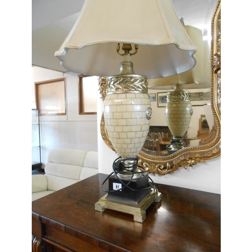 87 - A pair of modern ivory style urn shaped tablelamp bases on black and gilt metal bases, complete with... 