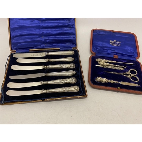 185 - A four piece manicure set with repousse decorated silver handles, in fitted red leather case retaile... 