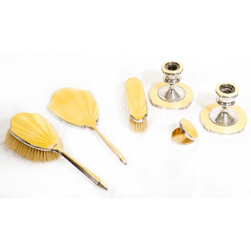 123 - A silver and yellow enamel dressing table set comprising:- hand mirror, hair brush, clothes brush, p... 