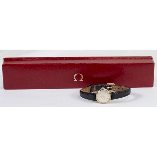 188 - A lady's Omega wristwatch in a 9ct. gold case, on a black leather strap, in fitted Omega box