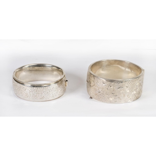 207 - A silver hinged bangle with engraved decoration of leaves to the top and a larger ditto