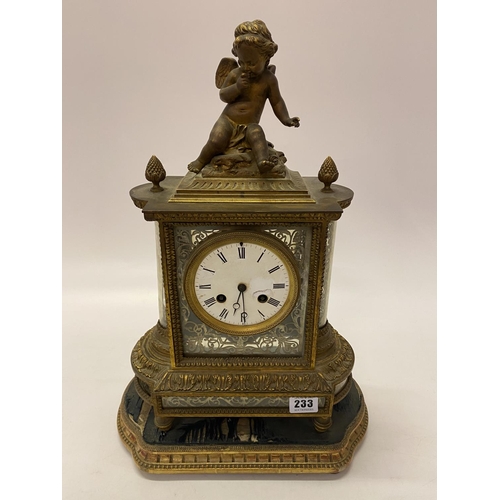 233 - A mantel clock, white enamel dial, striking movement on a bell, in a gilded spelter and glass case w... 