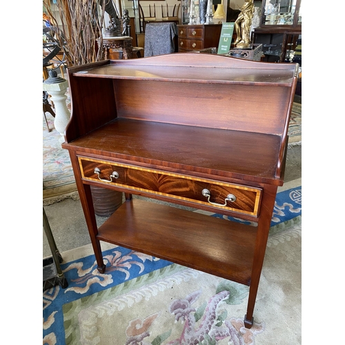 63 - A mahogany and satinwood inlaid bookcase fitted shelf, drawer under, on square legs united by undert... 