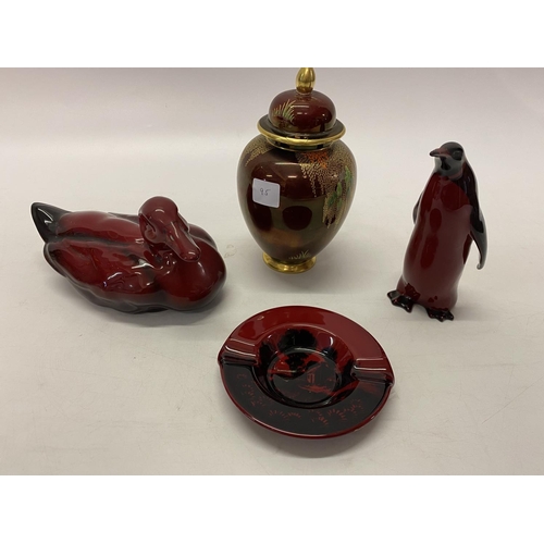 95 - A Royal Doulton flambe model of a duck, a similar ashtray, penguin and a Carlton Ware Rouge Royale c... 