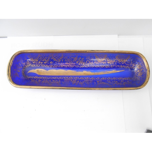 398 - A 19th Century blue glass pen tray with gilt decoration of flowers, leaf scrolls and quill to the ce... 