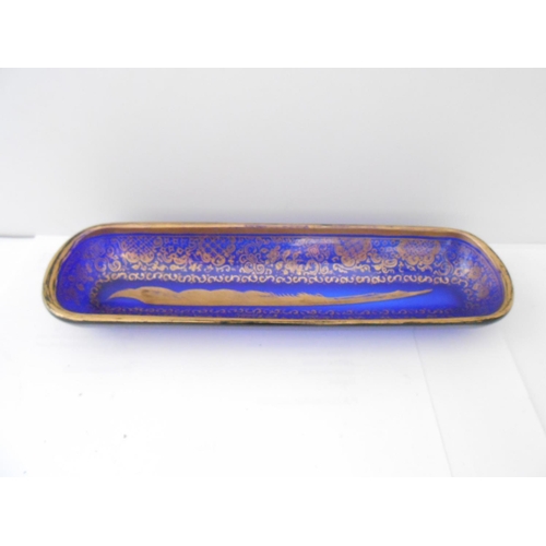 398 - A 19th Century blue glass pen tray with gilt decoration of flowers, leaf scrolls and quill to the ce... 