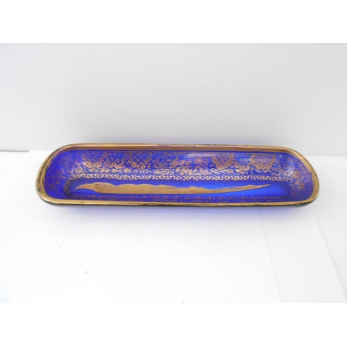 398 - A 19th Century blue glass pen tray with gilt decoration of flowers, leaf scrolls and quill to the ce... 