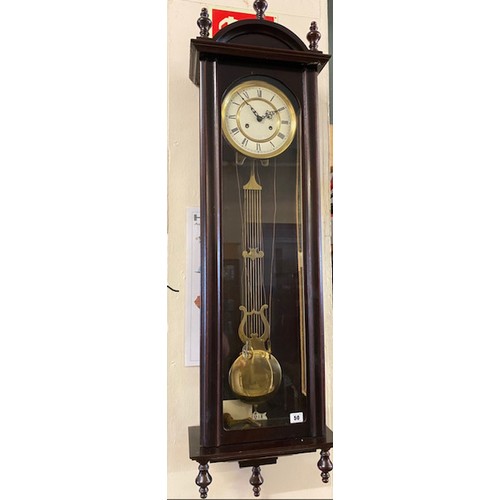 50 - A Victorian style Vienna regulator wall clock with circular dial, weights and pendulum, in a mahogan... 