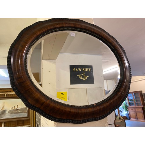 70 - An oak magazine rack, an oak firescreen with carved panel, a mahogany framed oval swing toilet mirro... 