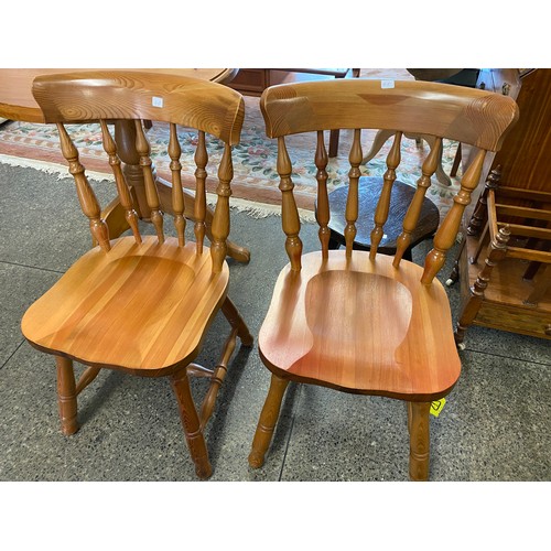 48 - A small pine kitchen table with circular top, on turned column and downswept legs and a pair of pine... 