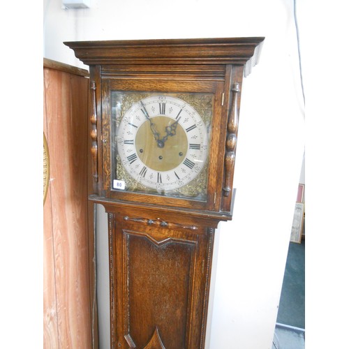 80 - A grandmother clock with brass dial, silvered chapter ring, in an oak case with panelled door and ba... 