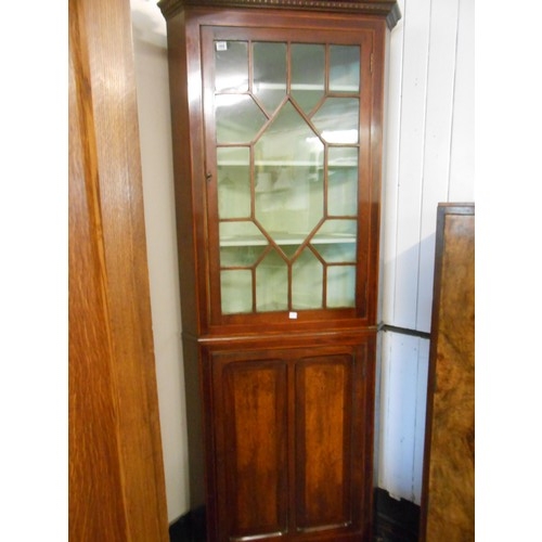 100 - An antique mahogany and satinwood line inlaid corner cabinet, on bracket feet