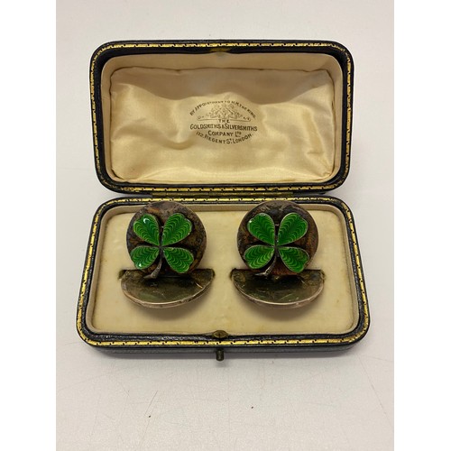 179 - A pair of silver place card holders decorated to the front with enamel shamrocks - London 1908, make... 