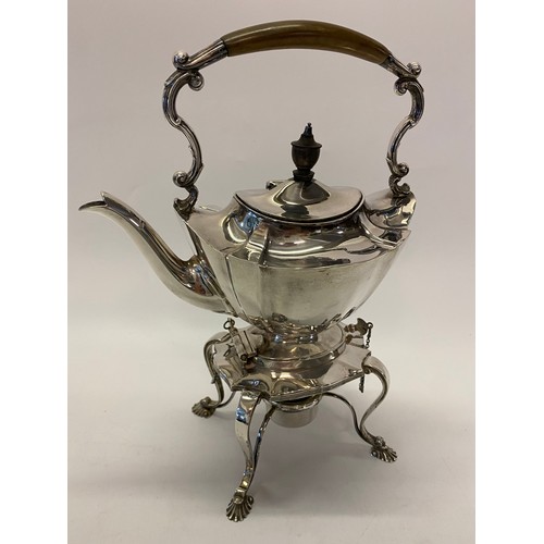 202 - A silver tea kettle on stand of serpentine form, the stand complete with burner, on four shell form ... 