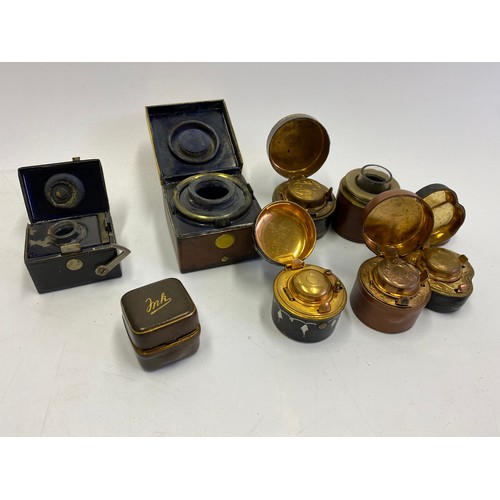 405 - Six leather travelling inkwells, a brass ditto, a brown leather inkwell with gilt leaf decorated lid... 