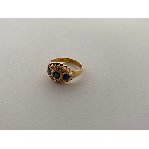 293 - A lady's ring set three sapphires and diamonds, on an 18ct. gold shank