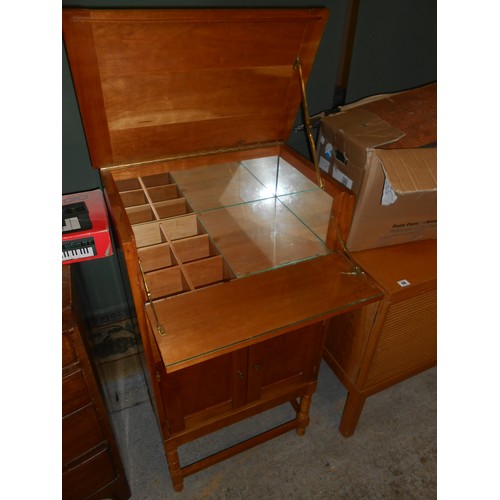 84 - A walnut cocktail cabinet with hinged top, fitted two doors under, on turned legs - 22in. wide