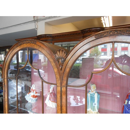 89 - A walnut display cabinet with double dome top, fitted two glass doors, panelled doors under, on carv... 