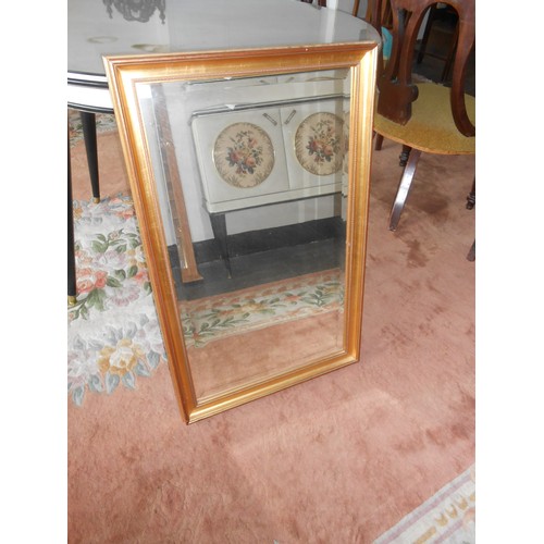 69 - A wall mirror in a decorative gilt frame - 52in. x 38in., a bevelled wall mirror in a gilt frame, a ... 