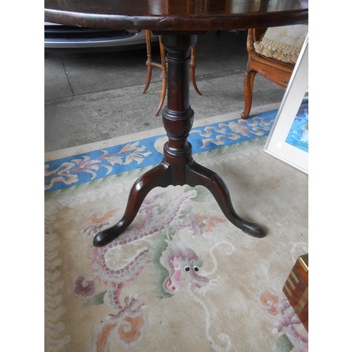 45 - A Georgian mahogany table with circular snap top, on gun barrel column and three downswept legs term... 