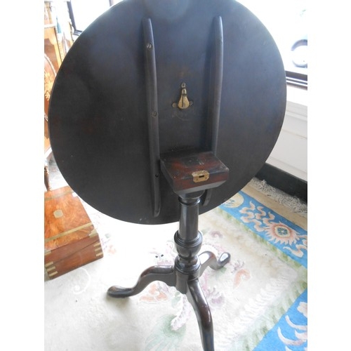 45 - A Georgian mahogany table with circular snap top, on gun barrel column and three downswept legs term... 