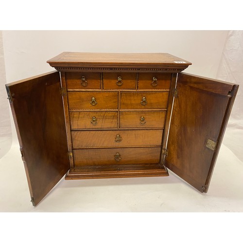 322 - A Georgian walnut spice cabinet fitted two panelled doors with fan paterae and inlaid shells, the in... 