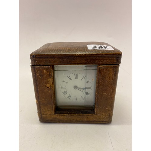 332 - A carriage clock, white enamel dial, in a brass and glass case, complete with leather travelling cas... 