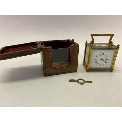 332 - A carriage clock, white enamel dial, in a brass and glass case, complete with leather travelling cas... 